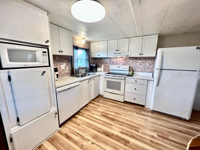 10819 London Drive Port Richey, FL 34668 - Photo 17 of 52 a kitchen with white cabinets and white appliances