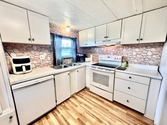 10819 London Drive Port Richey, FL 34668 - Photo 18 of 52 a kitchen with white cabinets stainless steel appliances and sink
