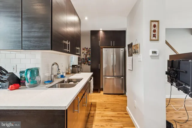 a kitchen with refrigerator a sink and a stove top oven