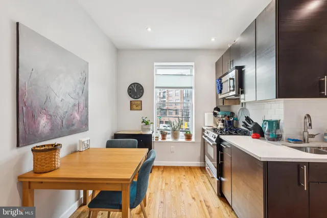 a kitchen with a table chairs refrigerator and sink