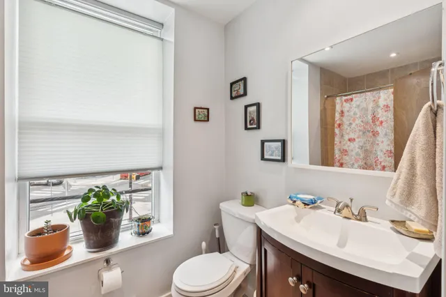 a bathroom with a sink mirror vanity and toilet