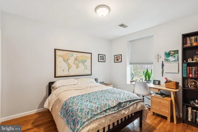 a bedroom with a bed and wooden floor