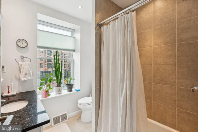 a bathroom with a granite countertop sink toilet a mirror and shower