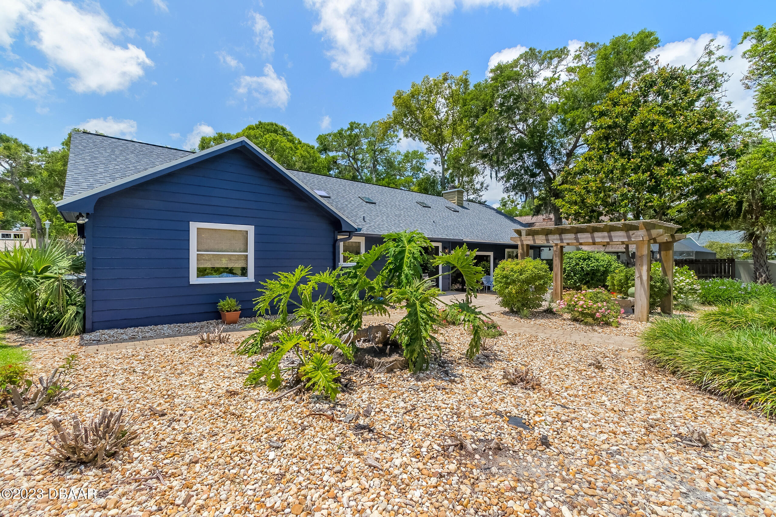 16 Eagle Court Ormond Beach, FL 32174 - Photo 42 of 50 a view of a backyard with potted plants and a large tree