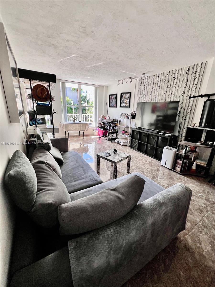 1300 Lincoln Road, Unit D304 Miami Beach, FL 33139 - Photo 11 of 24 a living room with furniture fireplace and a large window