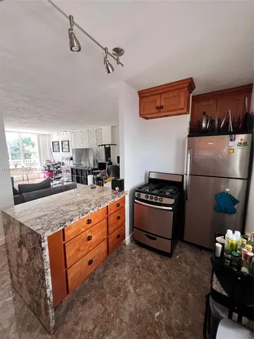 a kitchen with granite countertop a sink a counter space and cabinets