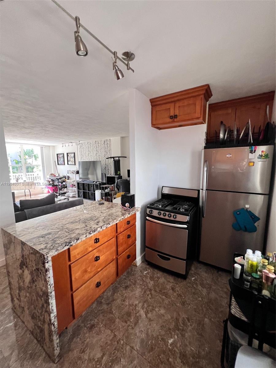 1300 Lincoln Road, Unit D304 Miami Beach, FL 33139 - Photo 15 of 24 a kitchen with granite countertop a sink a counter space and cabinets