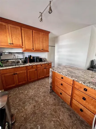 a room with stainless steel appliances granite countertop a sink a stove a granite counter tops and a window