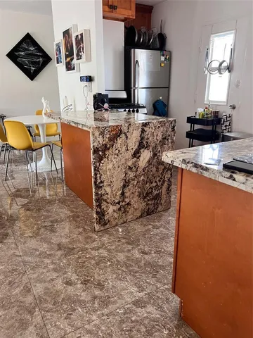 a kitchen with stainless steel appliances granite countertop a stove a sink and a refrigerator