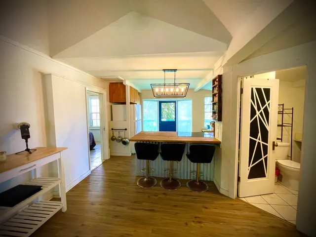 a kitchen with stainless steel appliances kitchen island granite countertop a sink dishwasher and wooden cabinets with wooden floor