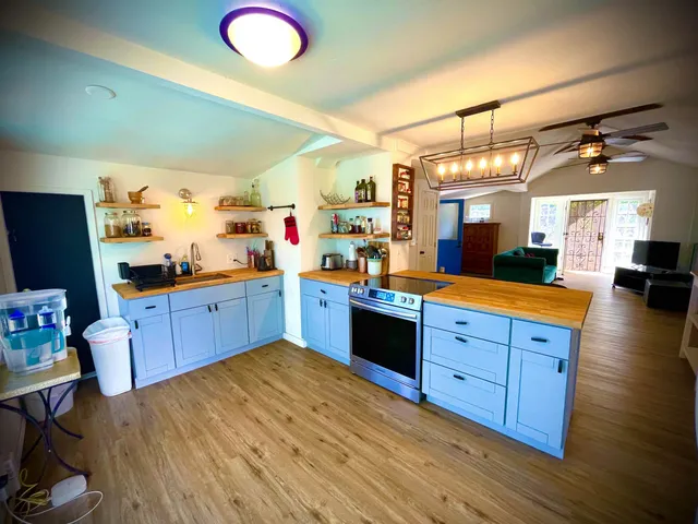 a kitchen with stainless steel appliances granite countertop a sink cabinets and wooden floor