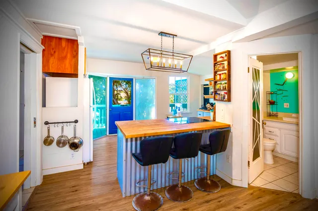 a room with stainless steel appliances furniture and a chandelier