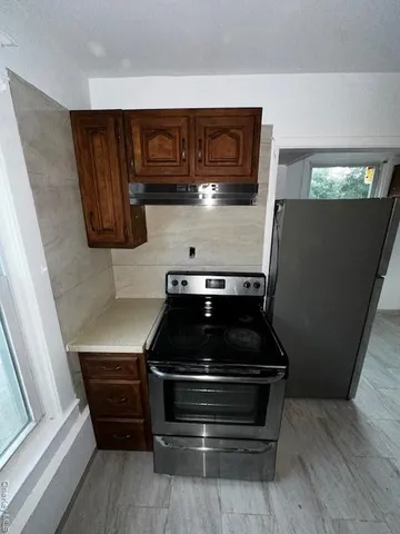 a kitchen with stainless steel appliances granite countertop a sink a stove a refrigerator a counter space and cabinets