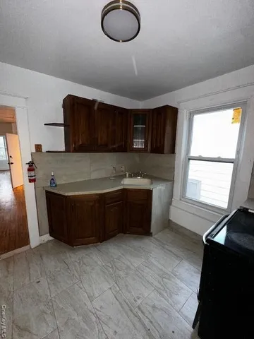 a view of a refrigerator in kitchen and a window