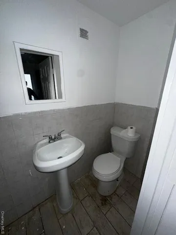 an empty room with wooden floor cabinet and windows