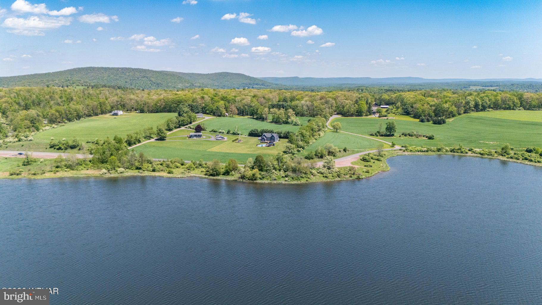 92 Easton Road Trout Run, PA 17771 - Photo 5 of 108 Serene lakeside retreat with lush fields.