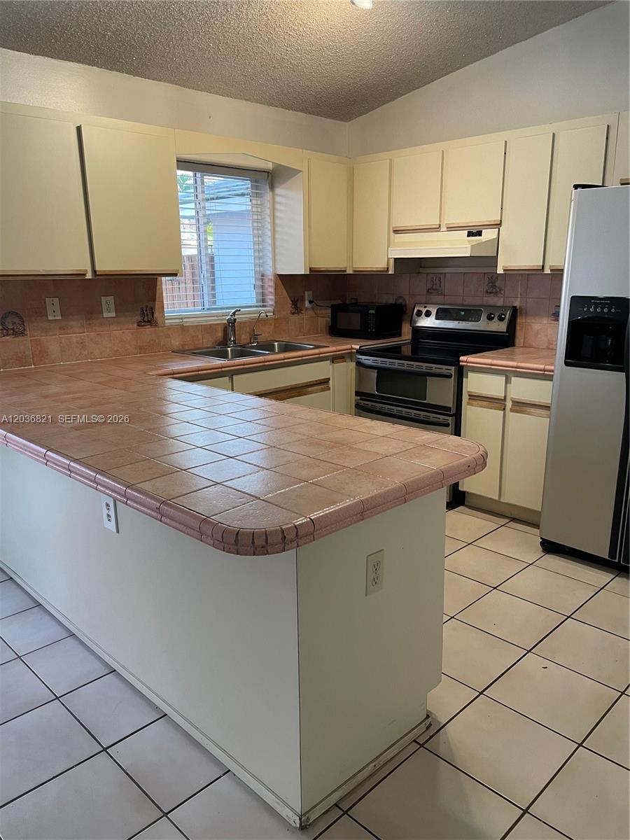 14770 Southwest 60th Street Miami, FL 33193 - Photo 6 of 16 a kitchen with stainless steel appliances granite countertop a stove a sink and a refrigerator