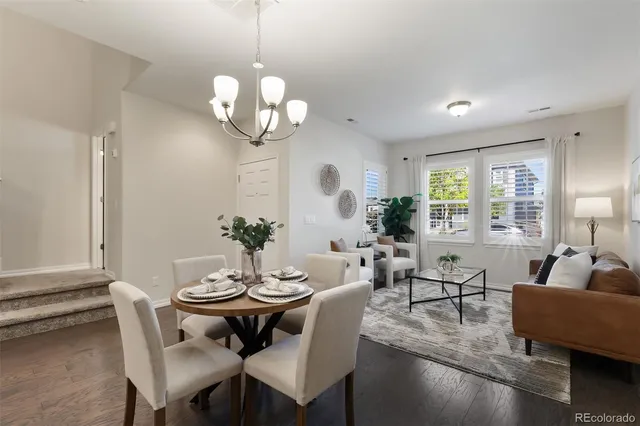a dining room with wooden floor a chandelier a glass table and chairs