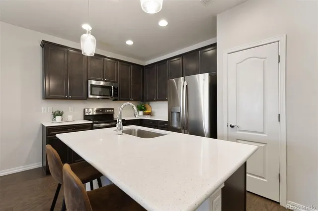 a kitchen with kitchen island a refrigerator stove microwave and cabinets