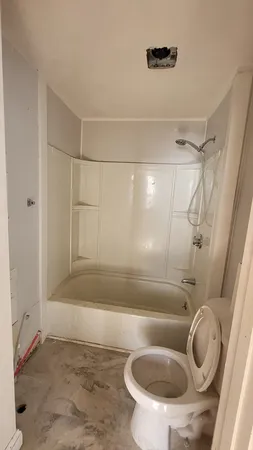 a bathroom with a toilet and a shower