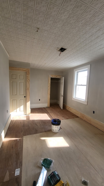 52 Willow Street, Unit 52 Lowell, MA 01852 - Photo 10 of 16 a view of an empty room with window and wooden floor