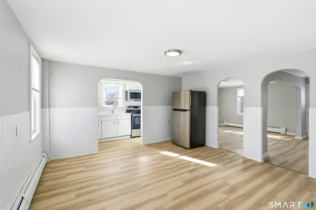 a view of a kitchen with wooden floor and refrigerator