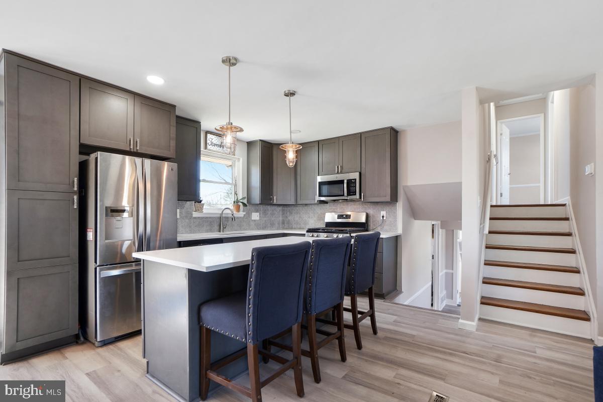 6703 Anders Terrace Springfield, VA 22151 - Photo 13 of 33 a kitchen with kitchen island wooden cabinets and stainless steel appliances