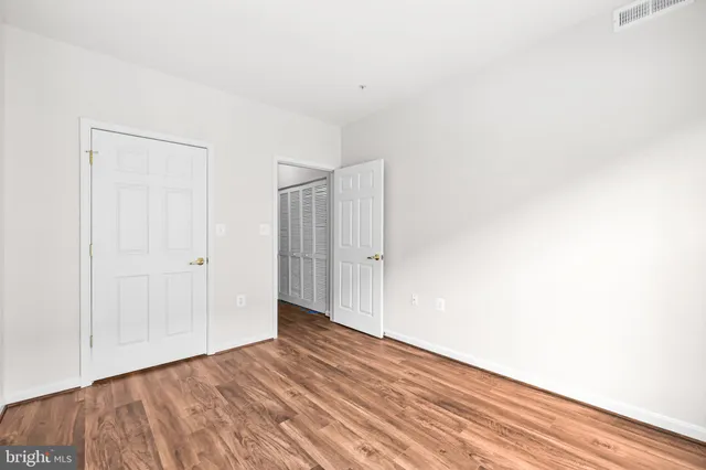a view of a livingroom with wooden floor a fireplace and windows