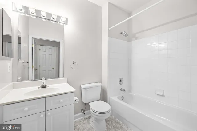 a view of an empty room with wooden floor fireplace and a window