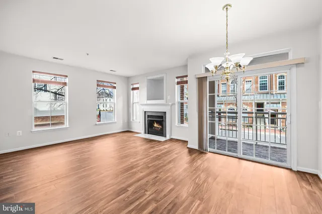 a view of empty room with wooden floor and window