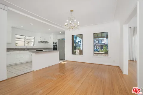 a view of an empty room with window and wooden floor