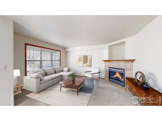 a living room with furniture a fireplace and a window