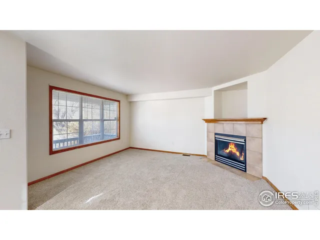 a open living room with a fireplace and a window