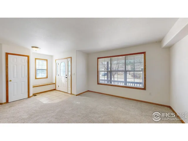 a living room with a window and a kitchen