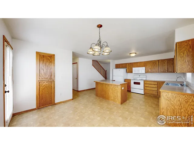 a living room with kitchen island furniture and a chandelier