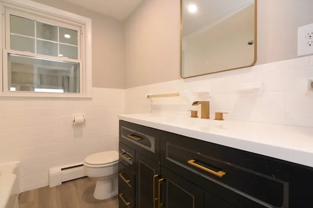 a bathroom with a sink a toilet and a mirror