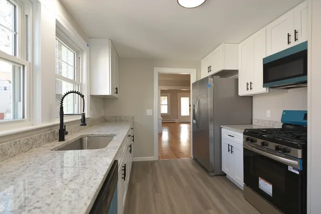 a kitchen with stainless steel appliances granite countertop a sink stove and refrigerator