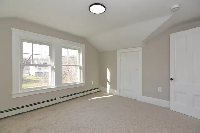 an empty room with windows and closet