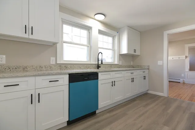 a kitchen with granite countertop cabinets stainless steel appliances a sink and a window