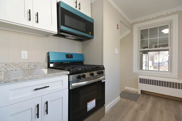 a kitchen with stainless steel appliances a stove a microwave a sink and cabinets