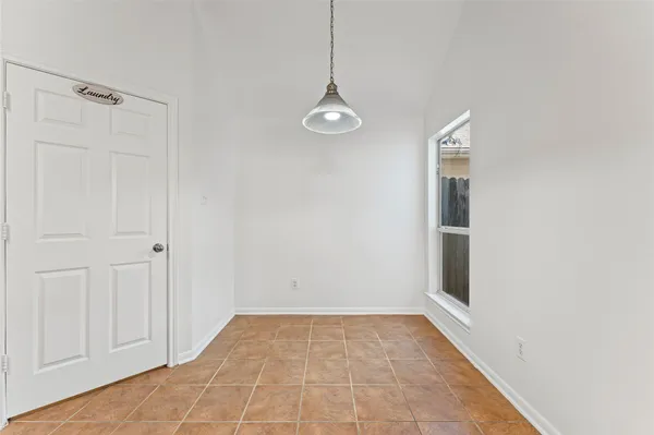 a view of a hallway with wooden floor and a window