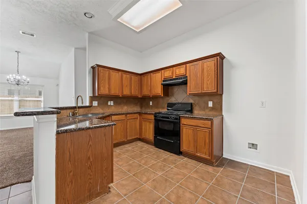 a kitchen with stainless steel appliances granite countertop a stove top oven a sink and dishwasher