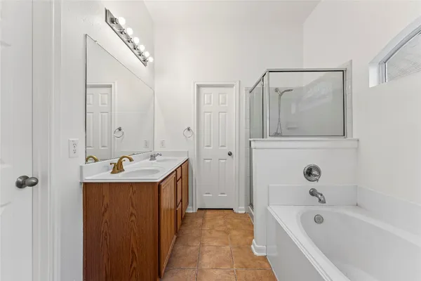 a bathroom with a tub sink and mirror
