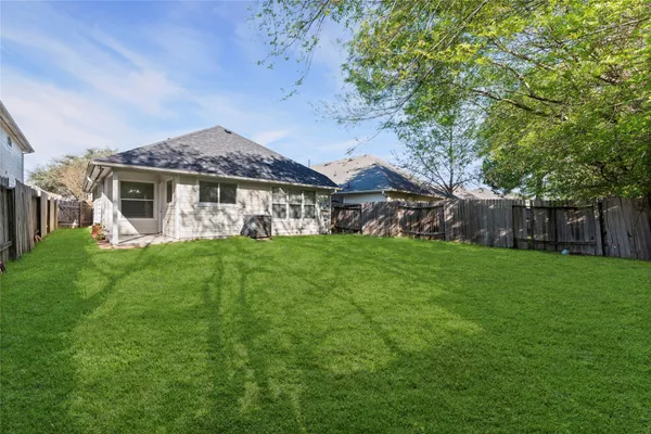 a view of a house with a yard potted plants and large tree