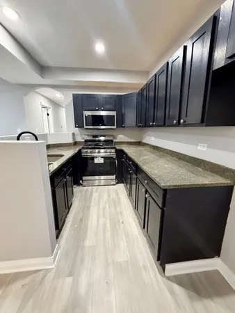 a kitchen with stainless steel appliances granite countertop a stove a sink dishwasher and a refrigerator