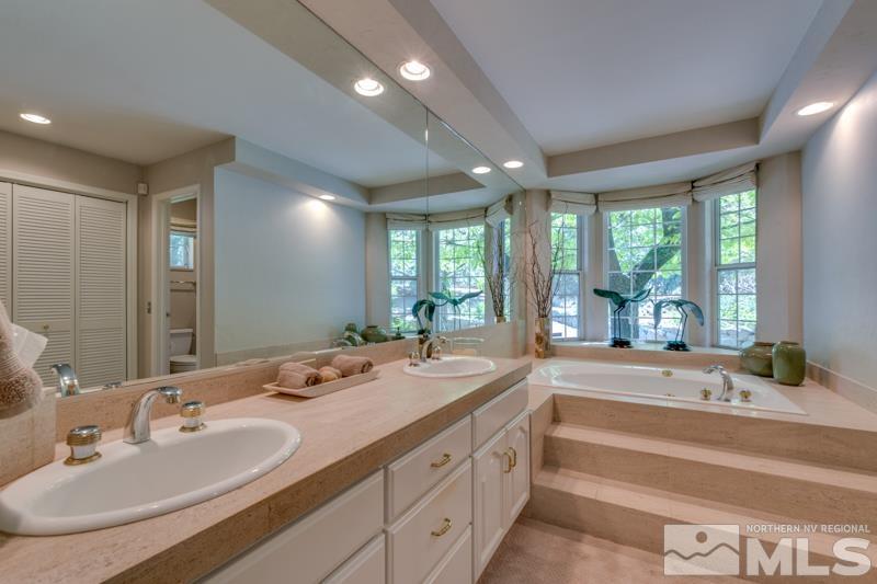 4275 Bitteroot Road Reno, NV 89519 - Photo 17 of 39 a spacious bathroom with sinks a large mirror and a bathtub next to a window