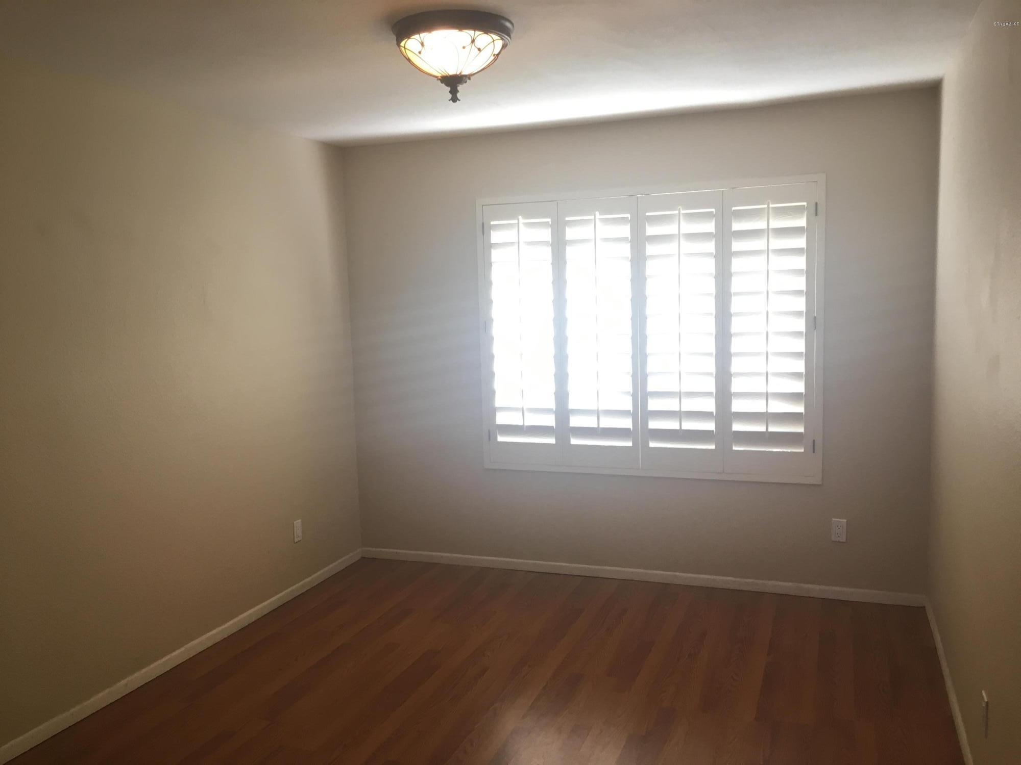 11813 North 60th Avenue Glendale, AZ 85304 - Photo 12 of 13 an empty room with wooden floor and windows