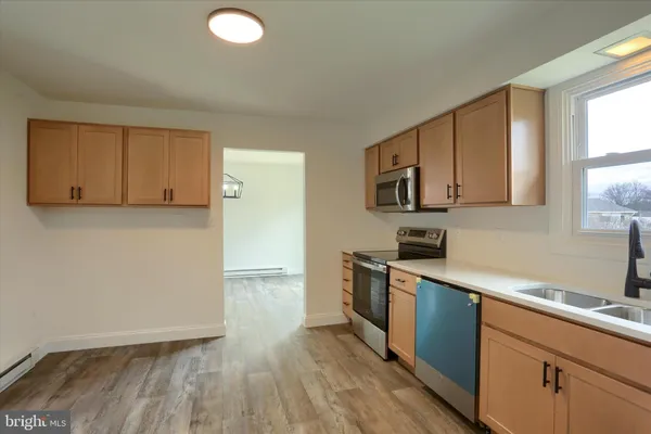 a kitchen with granite countertop a sink cabinets and stainless steel appliances