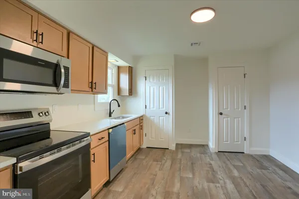 a kitchen with stainless steel appliances granite countertop a sink stove and microwave