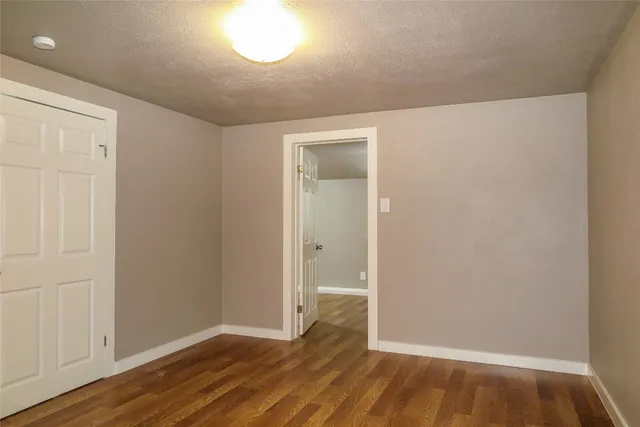 an empty room with wooden floor and closet